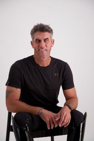 Man wearing Gallant Equestrian Mens Short Sleeve Tee in black, seated in a chair