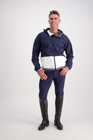 Man wearing Gallant Equestrian Mens Equestrian Rain Jacket in navy and bone, paired with jodhpurs and riding boots.
