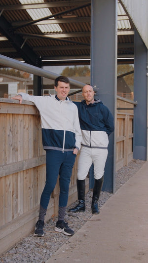 Two men standing on a wooden platform with a building in the background