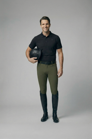Male equestrian wearing olive mens breeches full seat with black riding boots and helmet