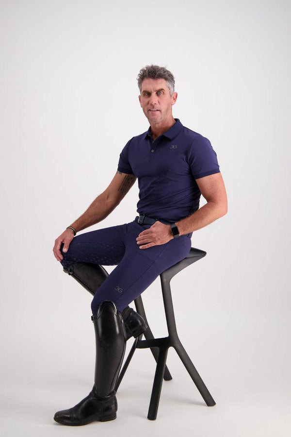 Gallant Equestrian Mens Equestrian Polo Shirt in navy, slim fit, worn by model seated on a stool.