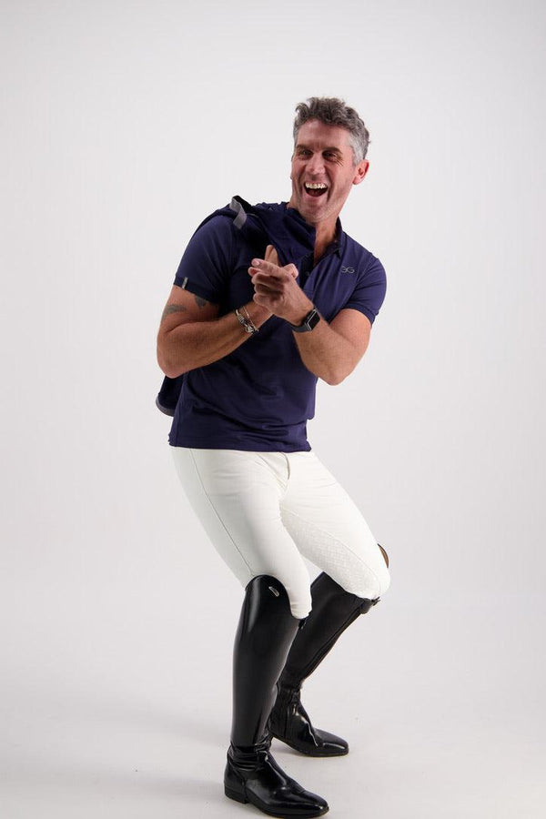 Man wearing a Gallant Equestrian Mens Equestrian Polo Shirt and jodhpurs, standing in a playful pose.