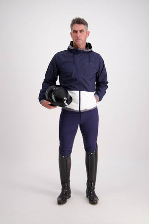 Man wearing Gallant Equestrian Mens Equestrian Rain Jacket in navy and bone, holding a helmet.