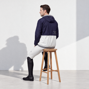 Mens Equestrian Rain Jacket in navy and white color-blocked fabric, with a hood, asymmetrical zip and subtle back logo.
