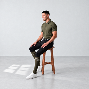 Mens Riding Socks in olive with black accents, knee-high design and subtle branded band, worn with riding apparel.